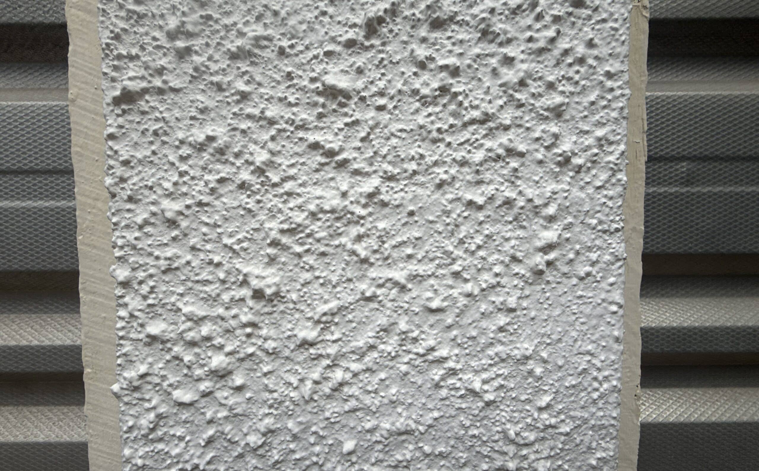 Textured Wall coating containing asbestos on a concrete beam