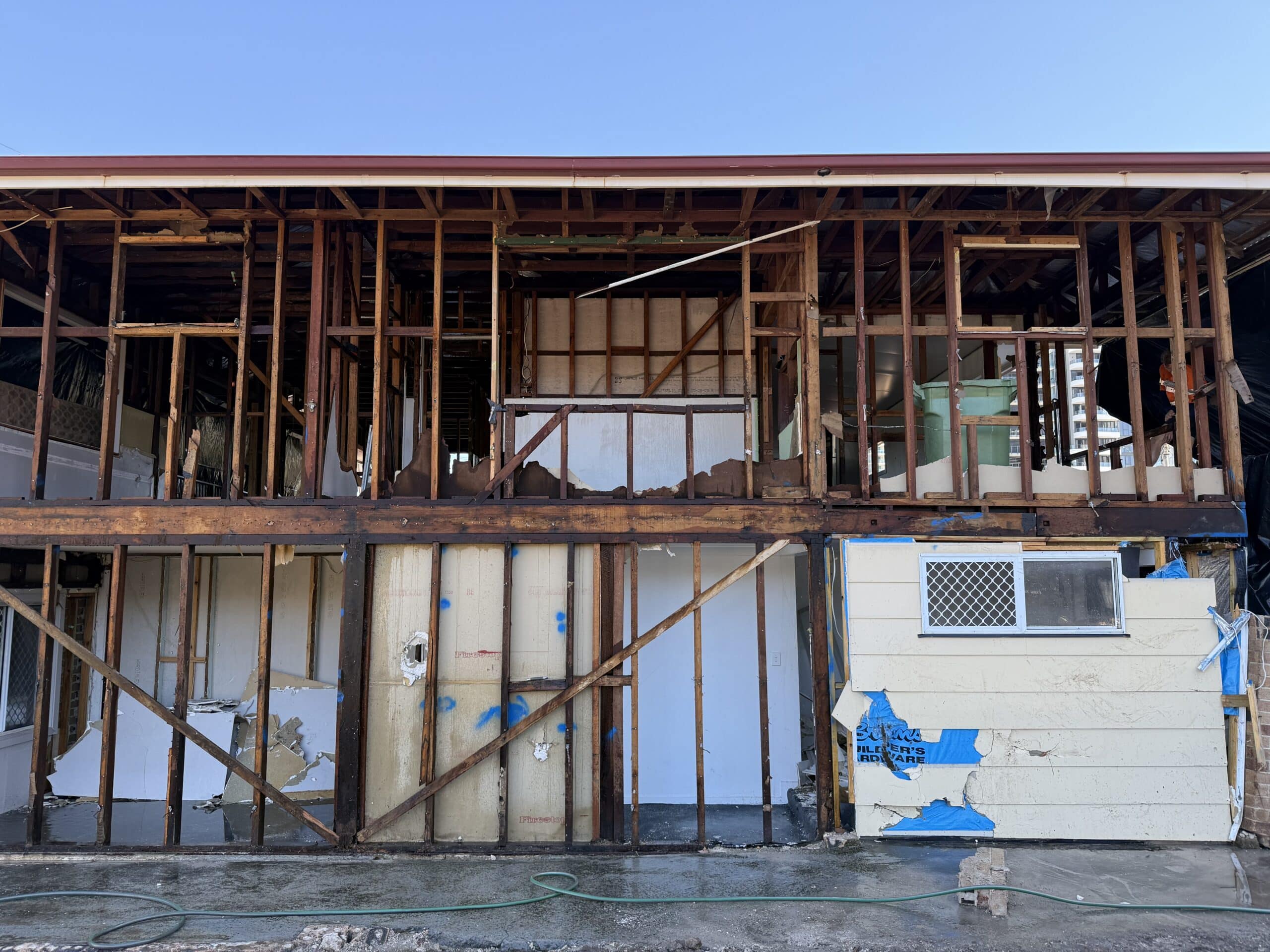 Exterior of a residential building with bonded asbestos cement sheeting removed and stripped back
