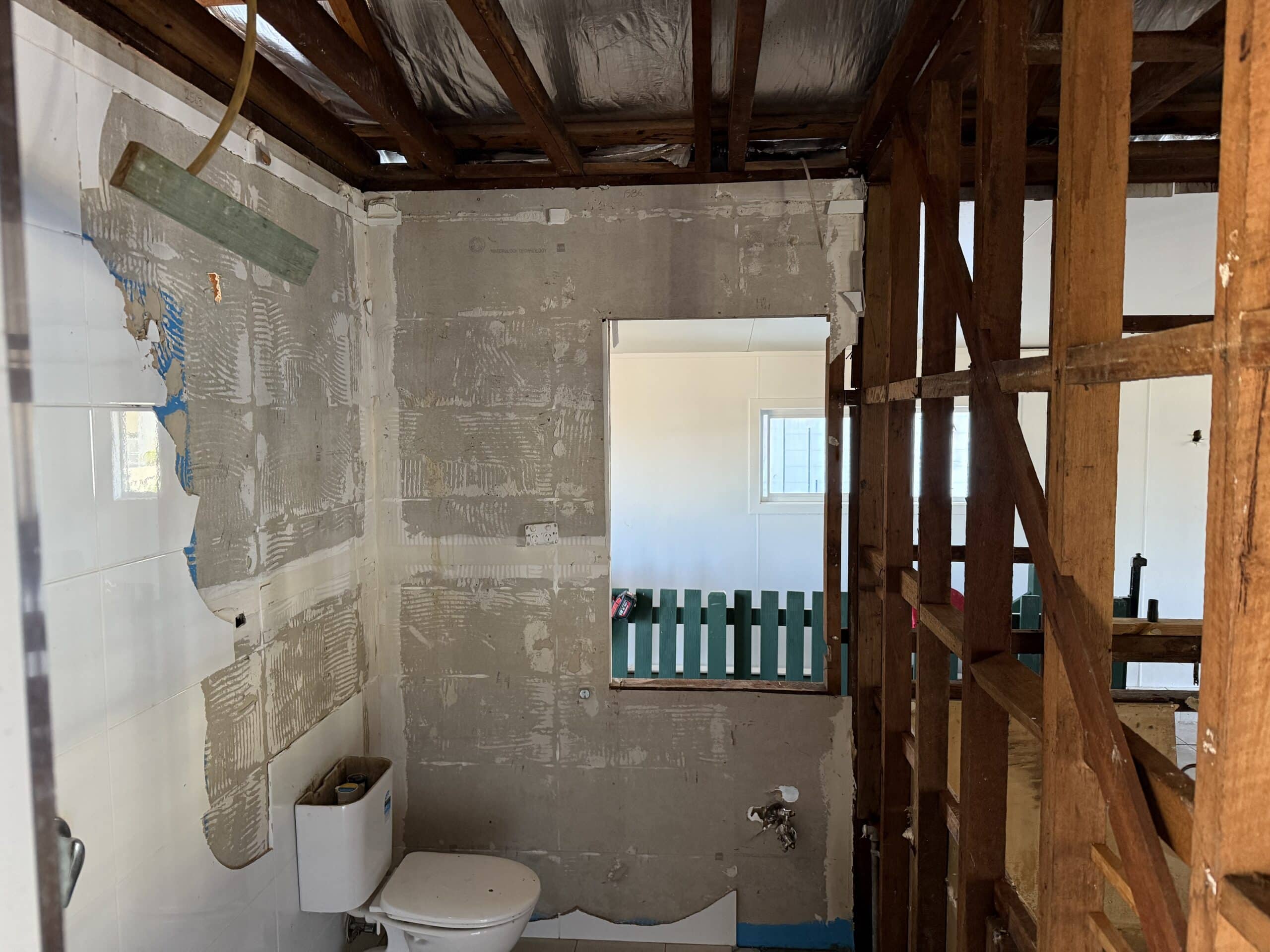 Asbestos cement sheeting installed as wall lining in a bathroom wet area.