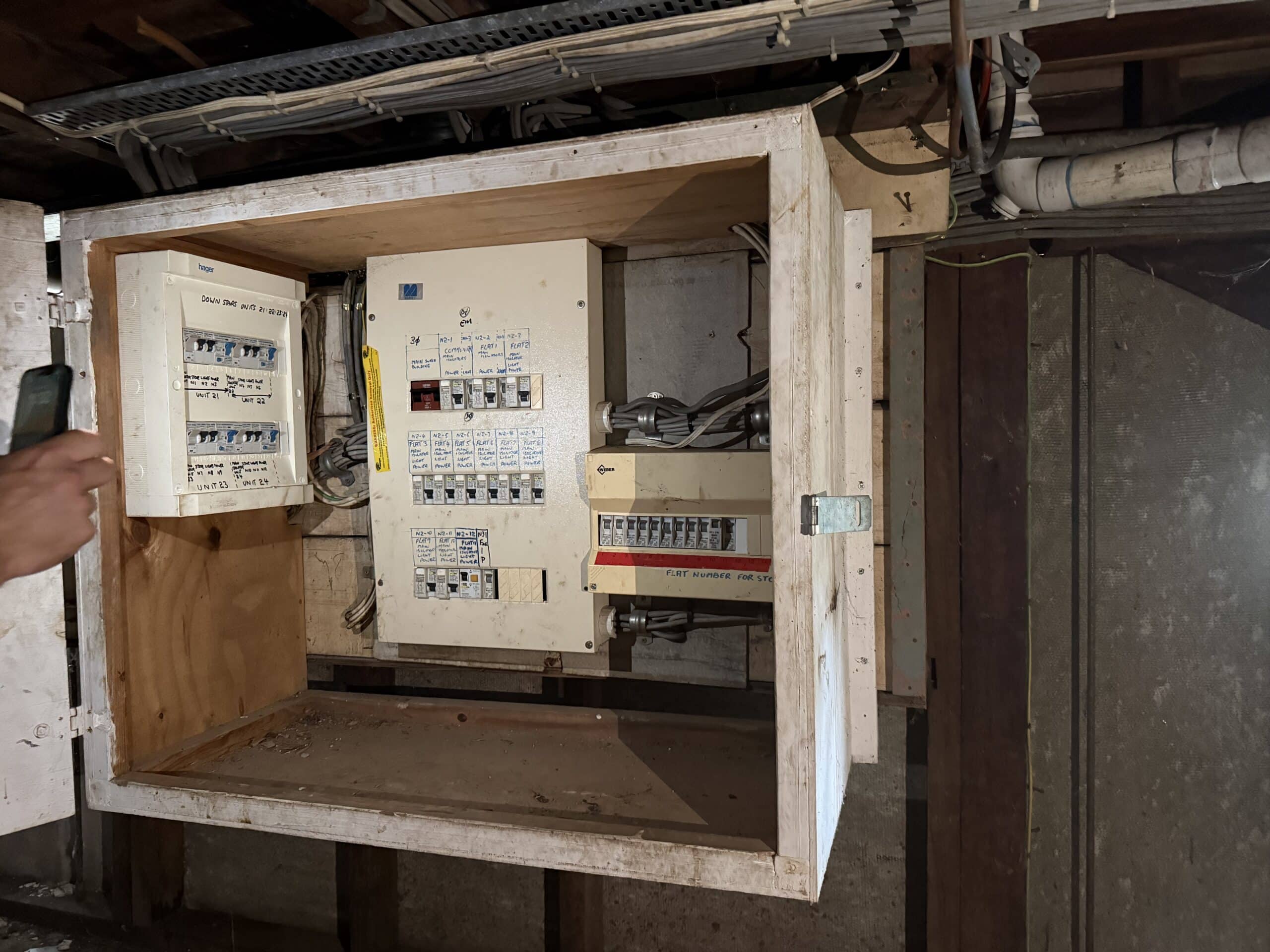 Asbestos cement backing board installed behind an electrical switchboard.
