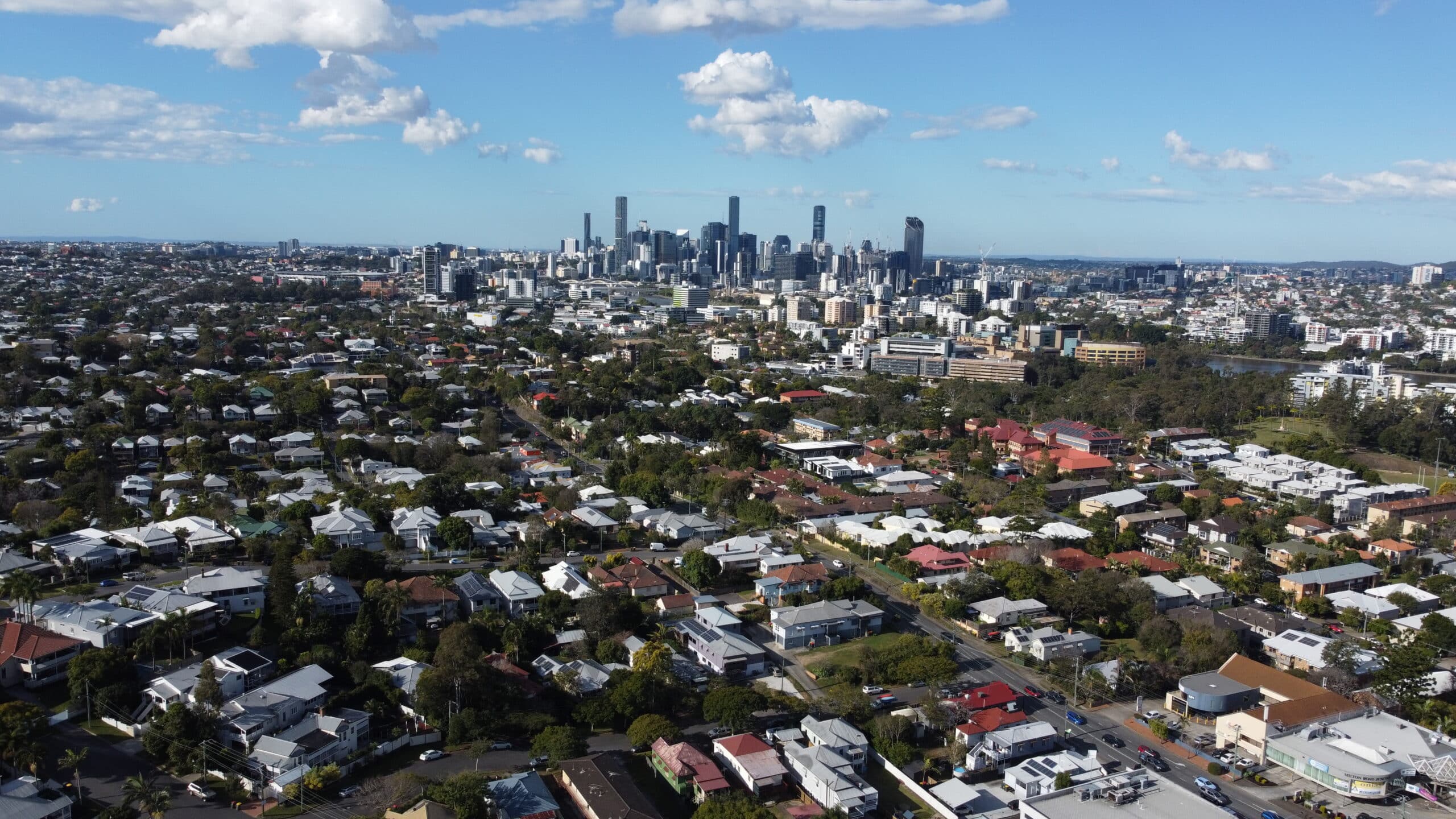 Aerial view of a Brisbane residential suburb with the city skyline in the distance