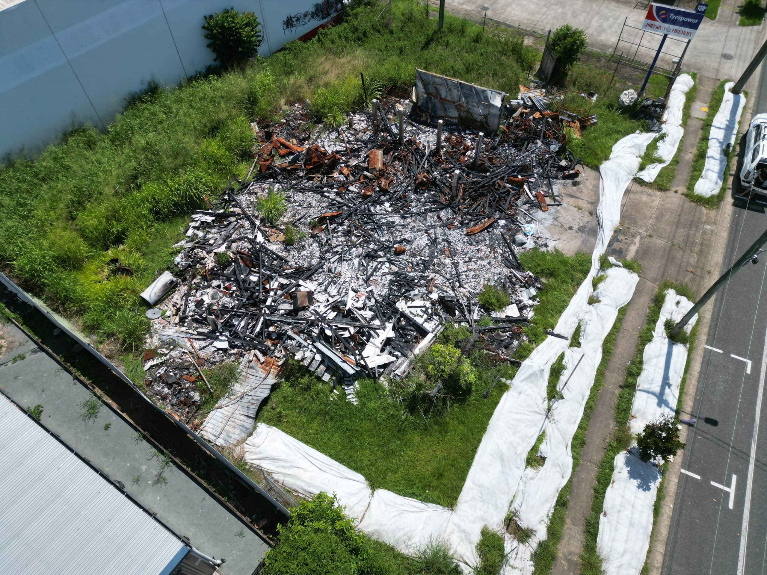 Fire-damaged building debris containing asbestos secured with PVA encapsulation before removal