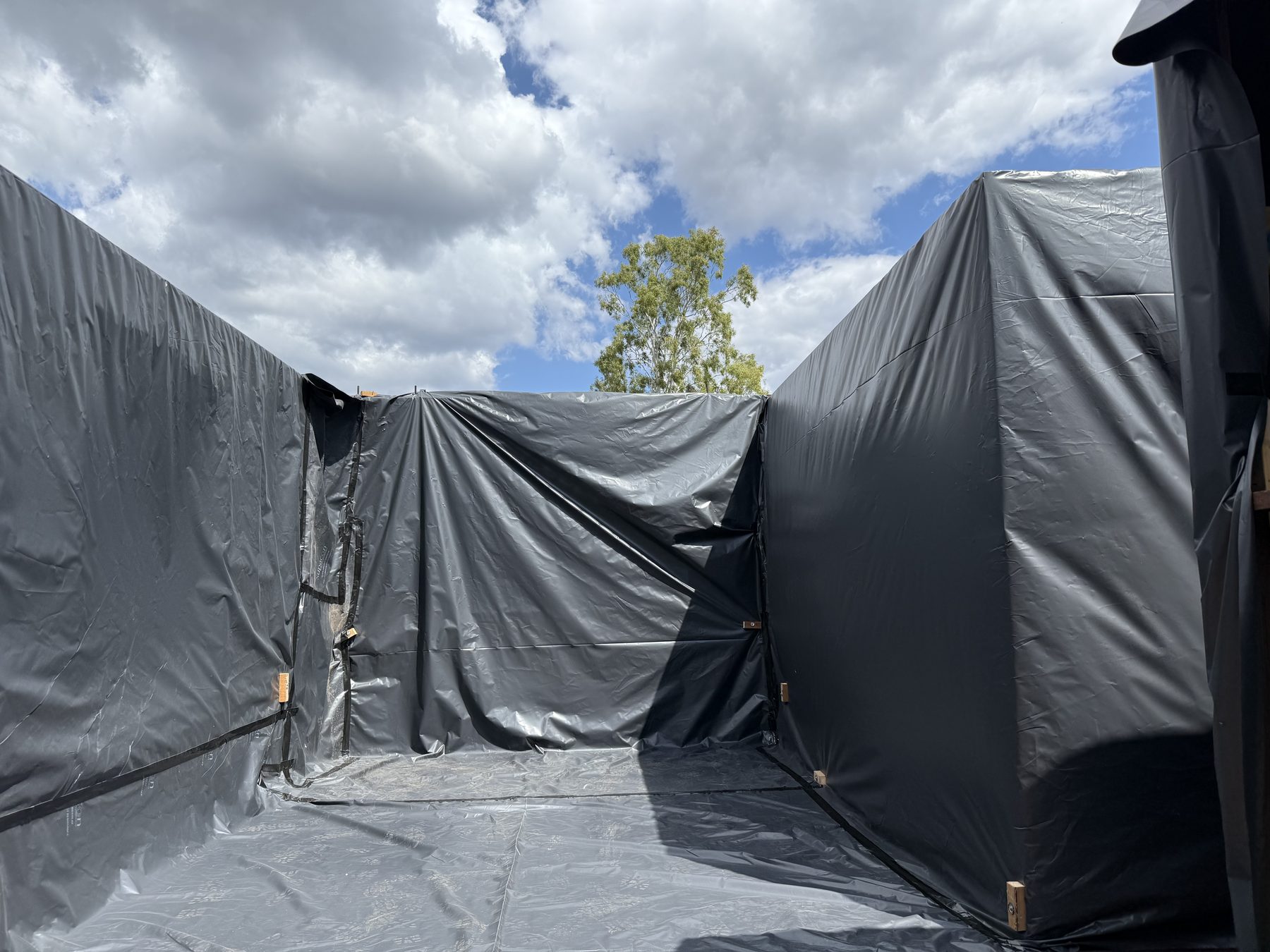 Sealed black poly containment enclosure set up for asbestos removal at Alligator Creek near Townsville