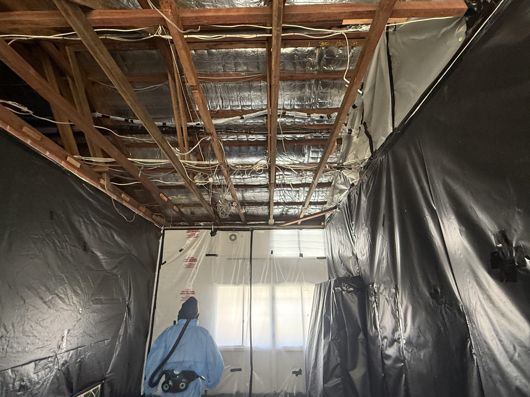 Removalist in PPE inside enclosure